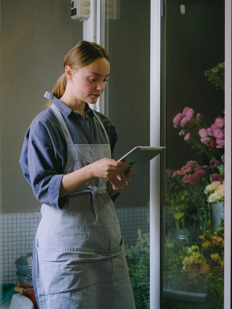 Florist checking orders on a tablet in her flower shop
