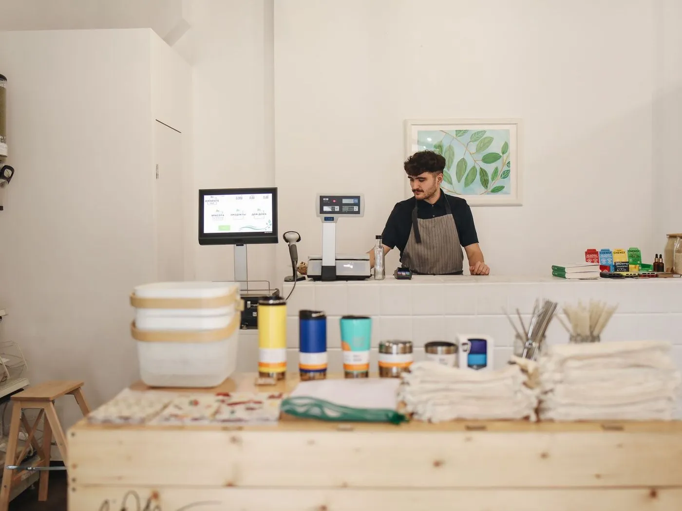 Shop owner behind the counter of his bright, minimal retail store